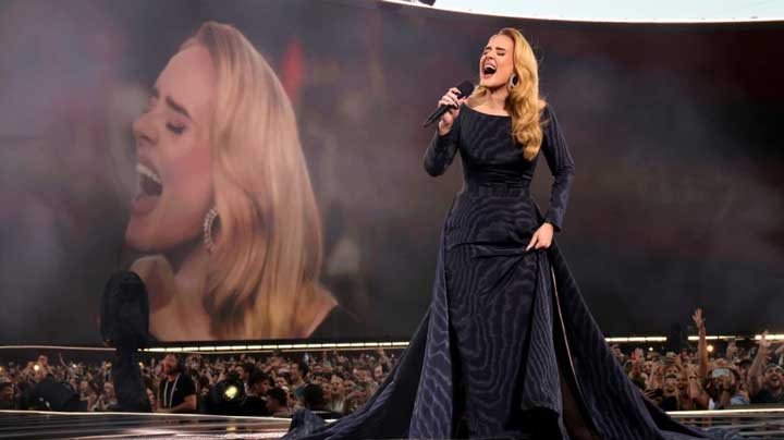 Adele greets fans modestly on the red carpet, showing quiet social boldness and grace.