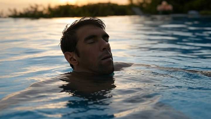Michael Phelps floats alone, deeply lost in thought, symbolizing his abstract, future-focused mindset.