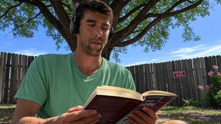 Michael Phelps reads quietly outdoors, reflecting his deep need for privacy and solitude.